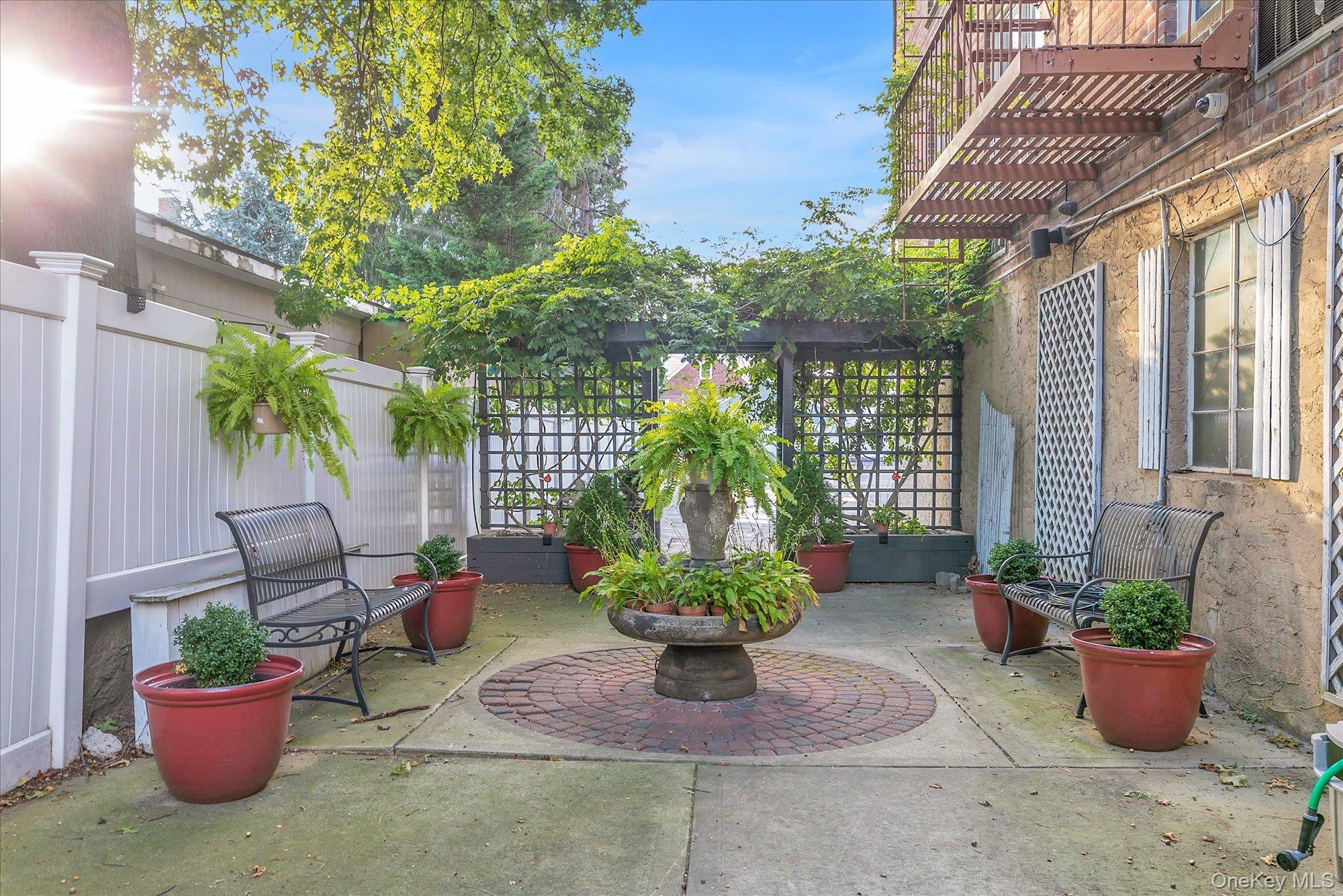 504 Merrick Road, Unit 4J Lynbrook, NY 11563 - Photo 23 of 28 a view of a backyard with plants and potted plants
