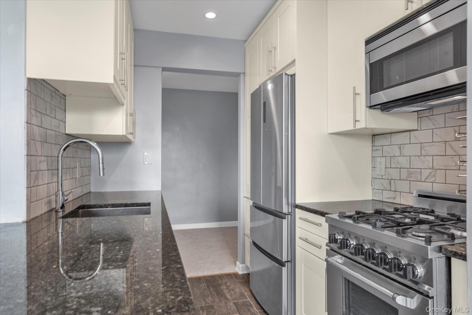 504 Merrick Road, Unit 4J Lynbrook, NY 11563 - Photo 8 of 28 a kitchen with granite countertop a stove and a refrigerator