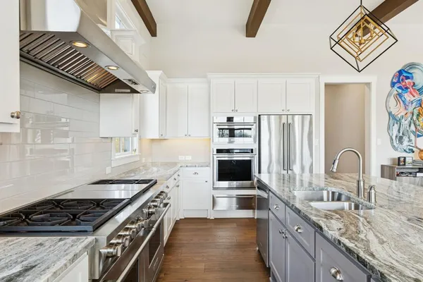 a kitchen with stainless steel appliances granite countertop a stove a sink and a refrigerator