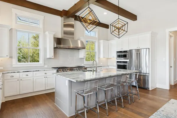 a kitchen with stainless steel appliances granite countertop a stove a sink and a refrigerator