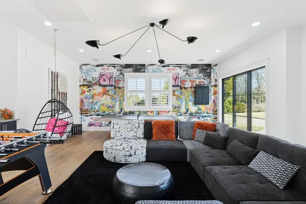 a living room with patio furniture and a chandelier