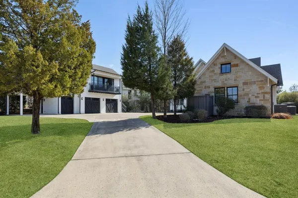 a front view of a house with a yard and trees
