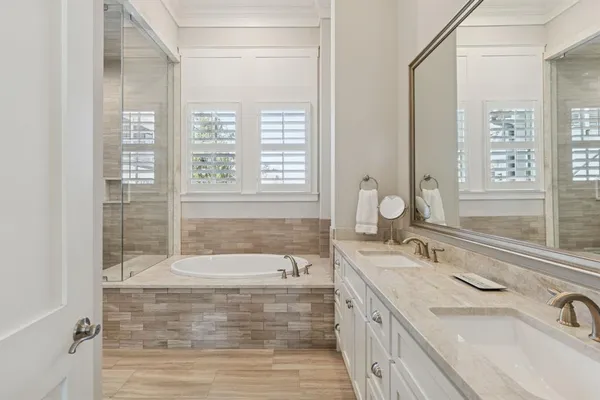 a bathroom with a granite countertop sink a mirror and a bathtub