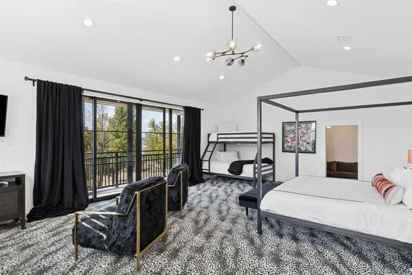 a spacious bedroom with a bed large window with couch