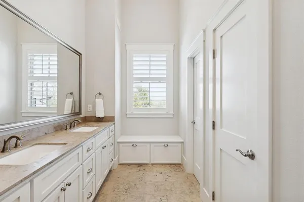a bathroom with a granite countertop tub sink and mirror