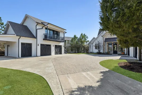 a front view of a house with a yard and trees