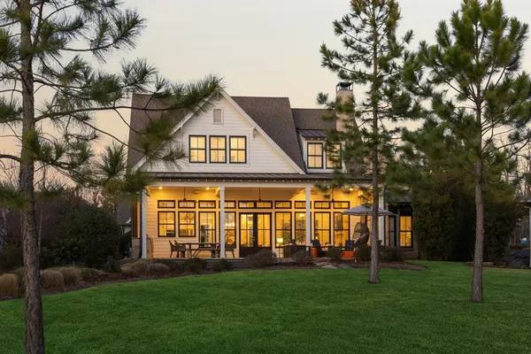 a view of a big house with a big yard and large trees