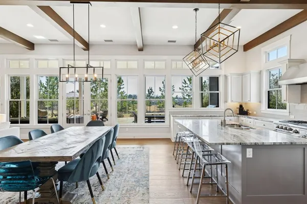 a view of a dining room and livingroom with furniture wooden floor a chandelier