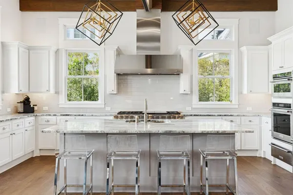 a kitchen with stainless steel appliances granite countertop a stove a sink and a microwave