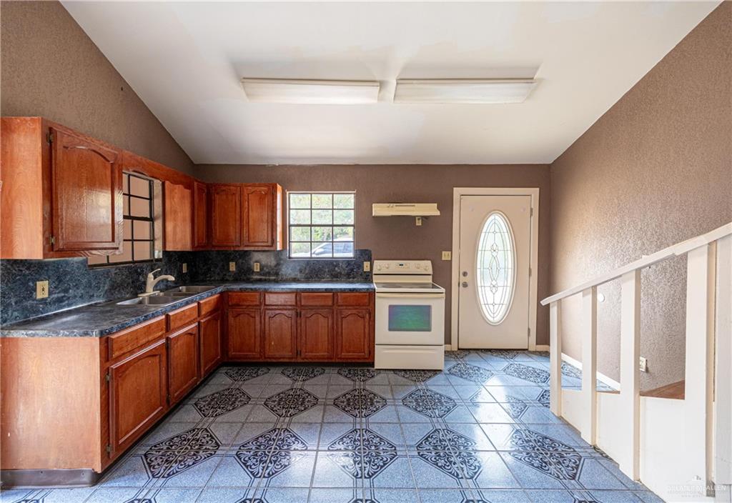 2415 East Expressway 83 Mission, TX 78572 - Photo 9 of 17 a large kitchen with granite countertop a large stove a sink dishwasher and a stove