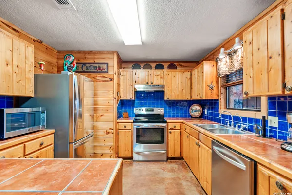 a kitchen with stainless steel appliances granite countertop a sink and a window