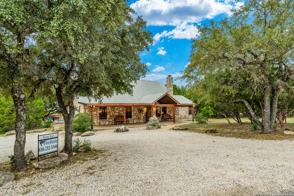 a view of a house with a patio and a yard