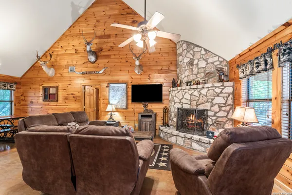a living room with furniture a flat screen tv and a fireplace