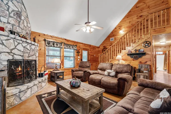 a living room with furniture a chandelier and a pool table