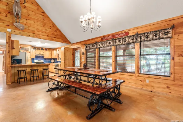 a kitchen with stainless steel appliances kitchen island granite countertop a table chairs sink and cabinets