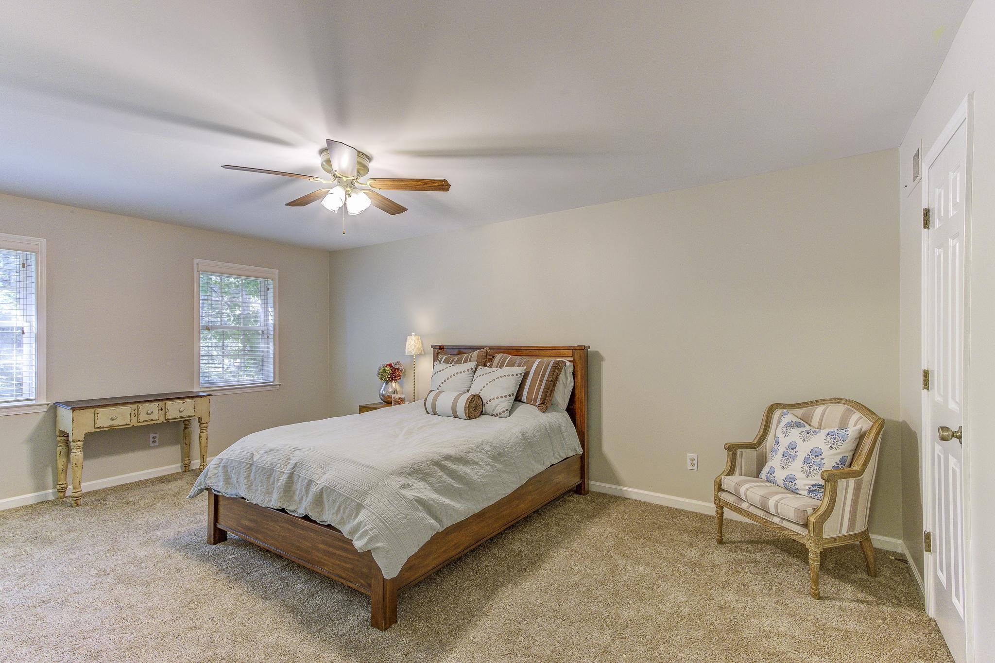 4414 Walnut Grove Road Memphis, TN 38117 - Photo 34 of 40 a bedroom with a bed a chair and a chandelier