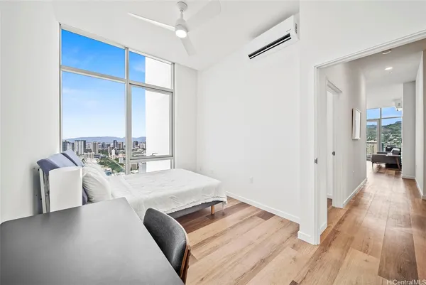 a living room with hard wood flooring and a kitchen