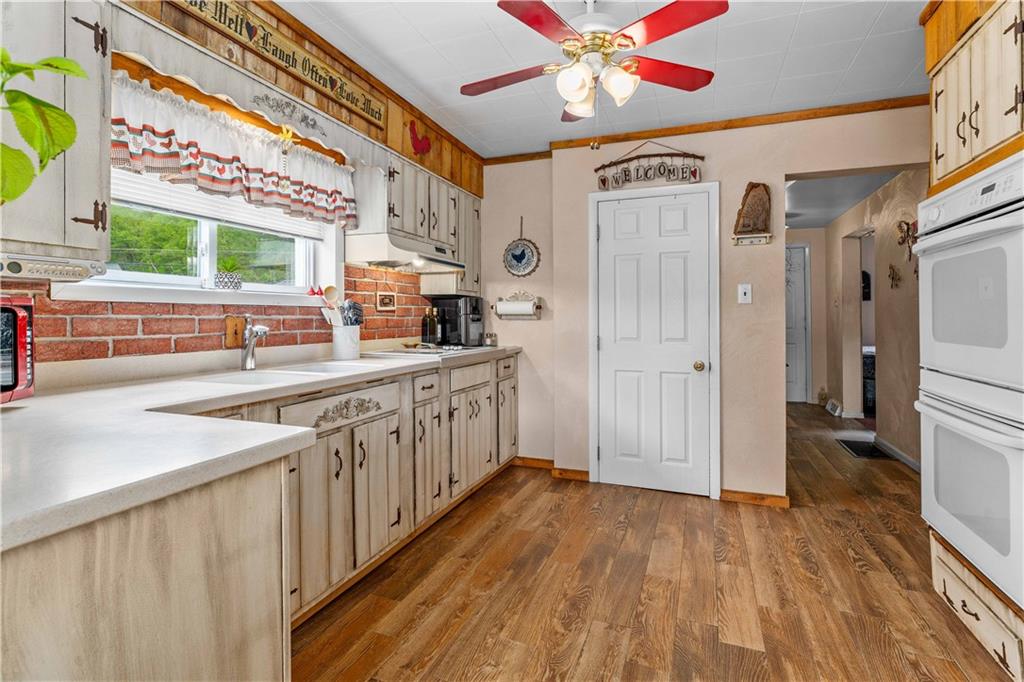 645 New Geneva Road Point Marion, PA 15474 - Photo 14 of 36 a kitchen with stainless steel appliances a sink cabinets and wooden floor