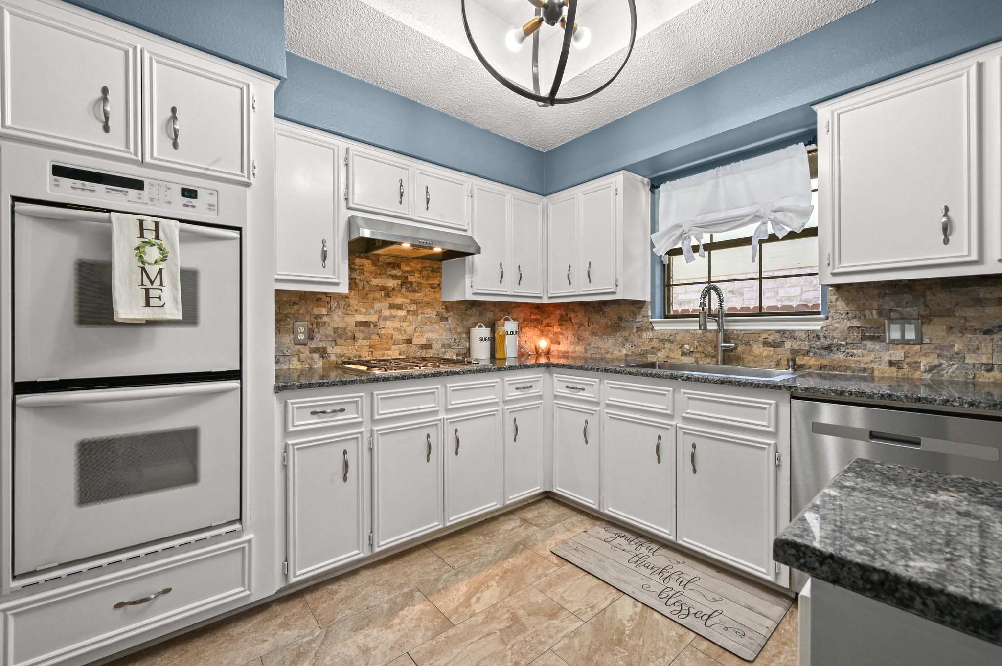 303 Pin Oak Drive Georgetown, TX 78628 - Photo 14 of 36 a kitchen with granite countertop white cabinets and white appliances
