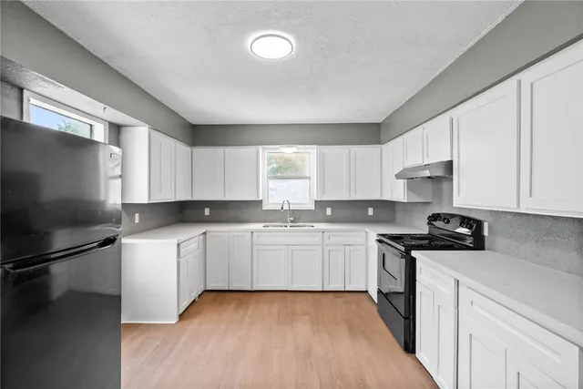a kitchen with a sink stove and refrigerator
