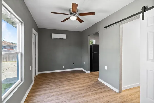 a view of room with wooden floor and a ceiling fan