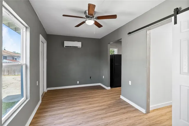 a view of room with wooden floor and a ceiling fan