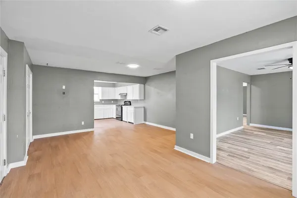 a view of empty room with wooden floor