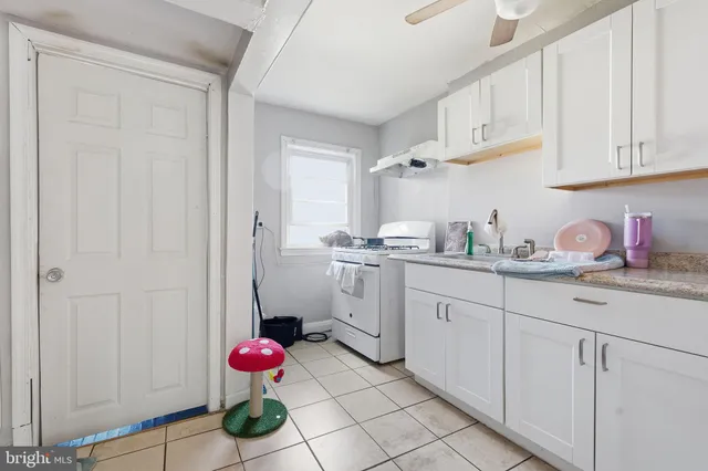 a kitchen with white cabinets and sink