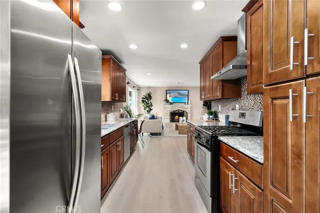 a kitchen with stainless steel appliances granite countertop a refrigerator a stove a sink and a microwave