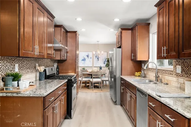 a kitchen with kitchen island granite countertop a sink stove and cabinets