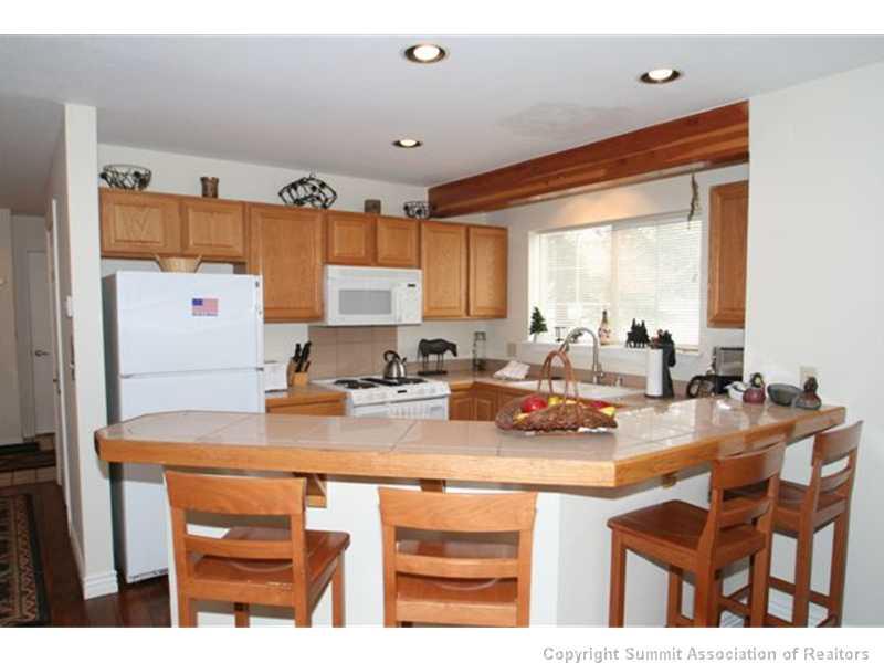 487 Main Street, Unit A Frisco, CO 80443 - Photo 2 of 22 a kitchen with a sink a stove and chairs