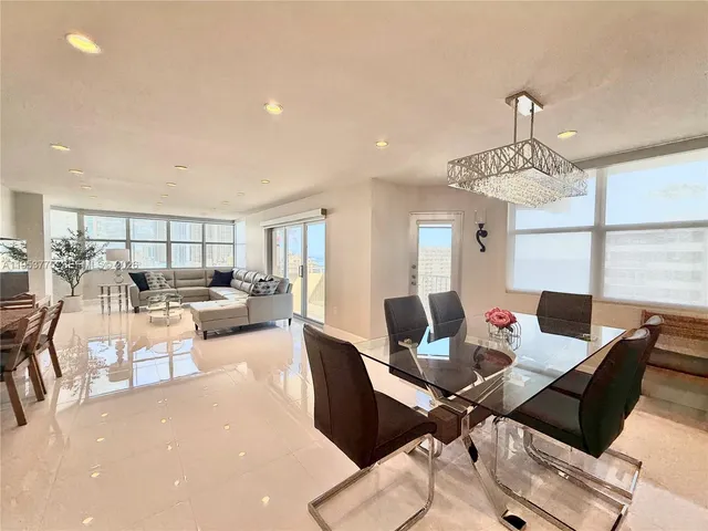 a living room with furniture a chandelier and a dining table