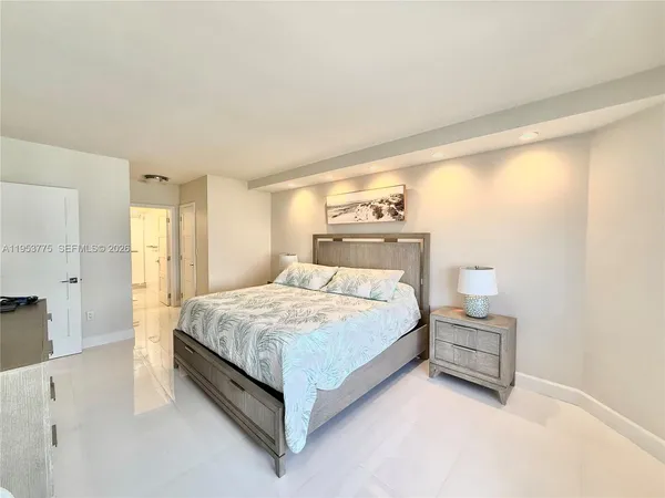 a bedroom with a bed lamp and a large window