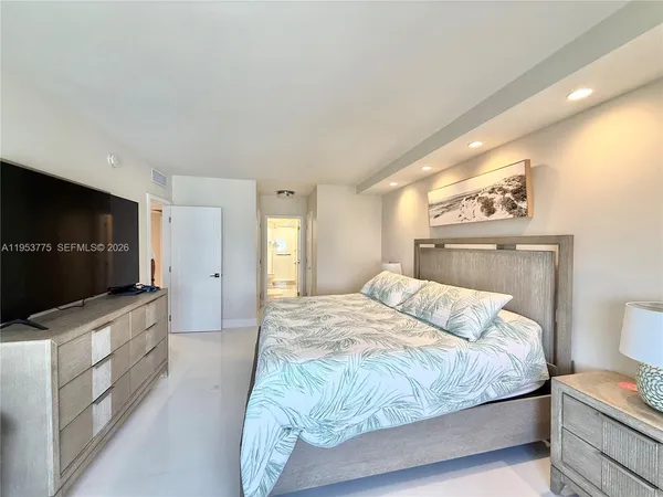 a bedroom with a bed and a flat screen tv