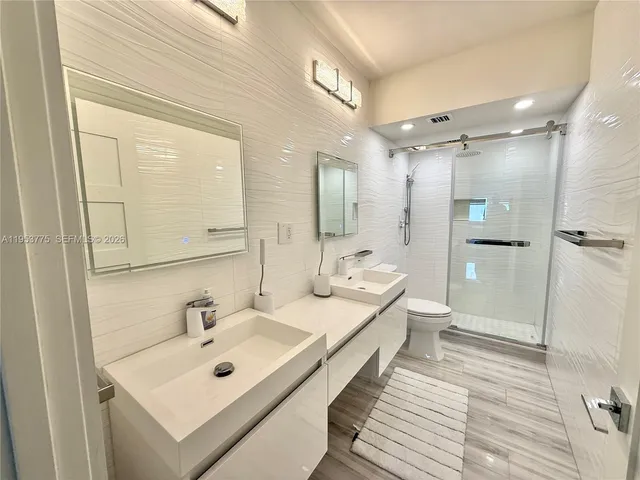 a bathroom with a sink mirror and shower