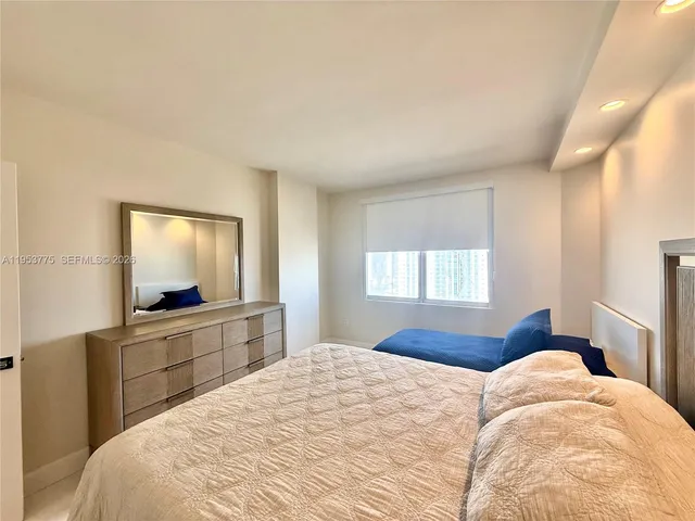 a bedroom with a large bed and a flat screen tv