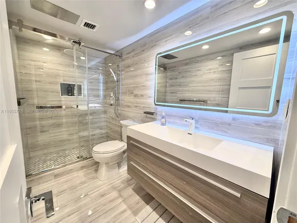 a bathroom with a sink a toilet and shower