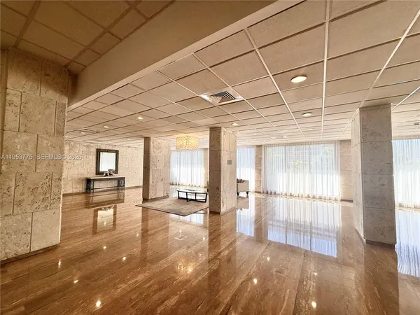 a view of empty room with wooden floor and seating space