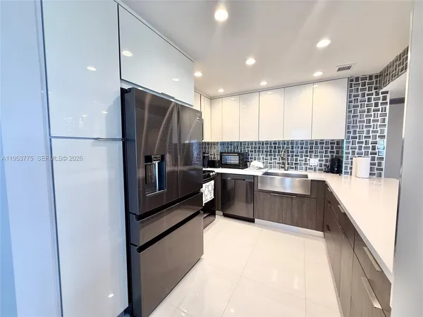 a kitchen with granite countertop a refrigerator and a sink