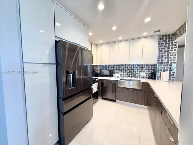 a kitchen with granite countertop a refrigerator and a sink