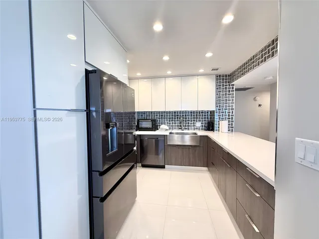 a large kitchen with a large counter top appliances and cabinets