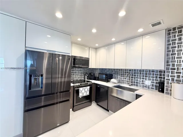 a kitchen with granite countertop stainless steel appliances and sink