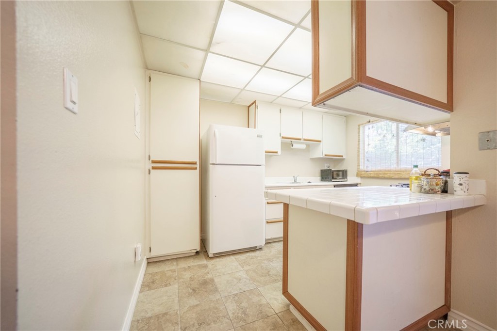 2255 Cahuilla Street, Unit 32 Colton, CA 92324 - Photo 14 of 35 a kitchen with kitchen island a sink a refrigerator a stove a microwave and cabinets