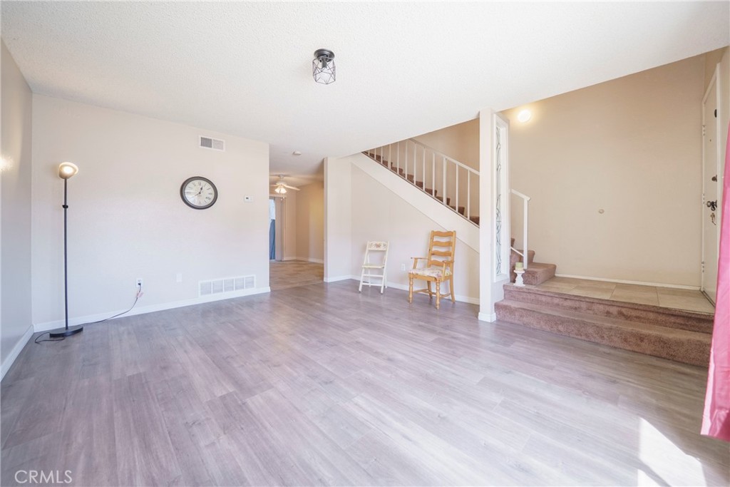 2255 Cahuilla Street, Unit 32 Colton, CA 92324 - Photo 8 of 35 a view of an empty room with wooden floor and stairs