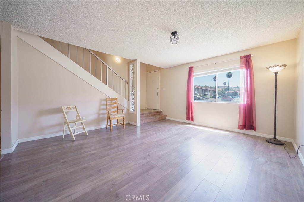 2255 Cahuilla Street, Unit 32 Colton, CA 92324 - Photo 9 of 35 a view of an empty room with wooden floor and stairs