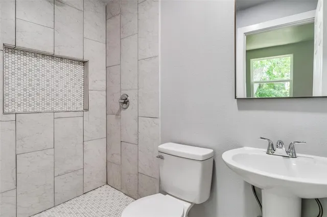 a bathroom with a toilet sink and shower