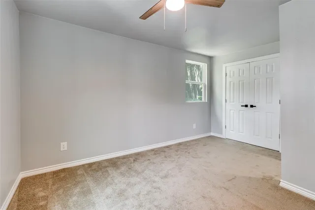 an empty room with chandelier fan