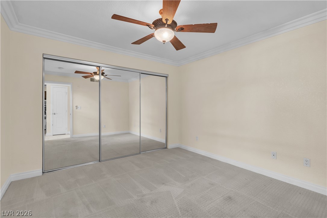 8101 West Flamingo Road, Unit 2001 Las Vegas, NV 89147 - Photo 23 of 28 Mirrored closet doors and a ceiling fan enhance this cozy bedroom, creating a comfortable living space.