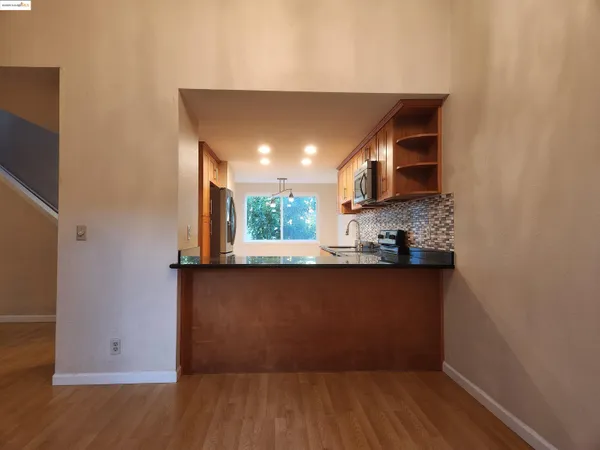 a view of a kitchen with wooden floor and a window