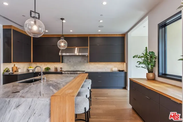 a large kitchen with granite countertop a sink and a stove